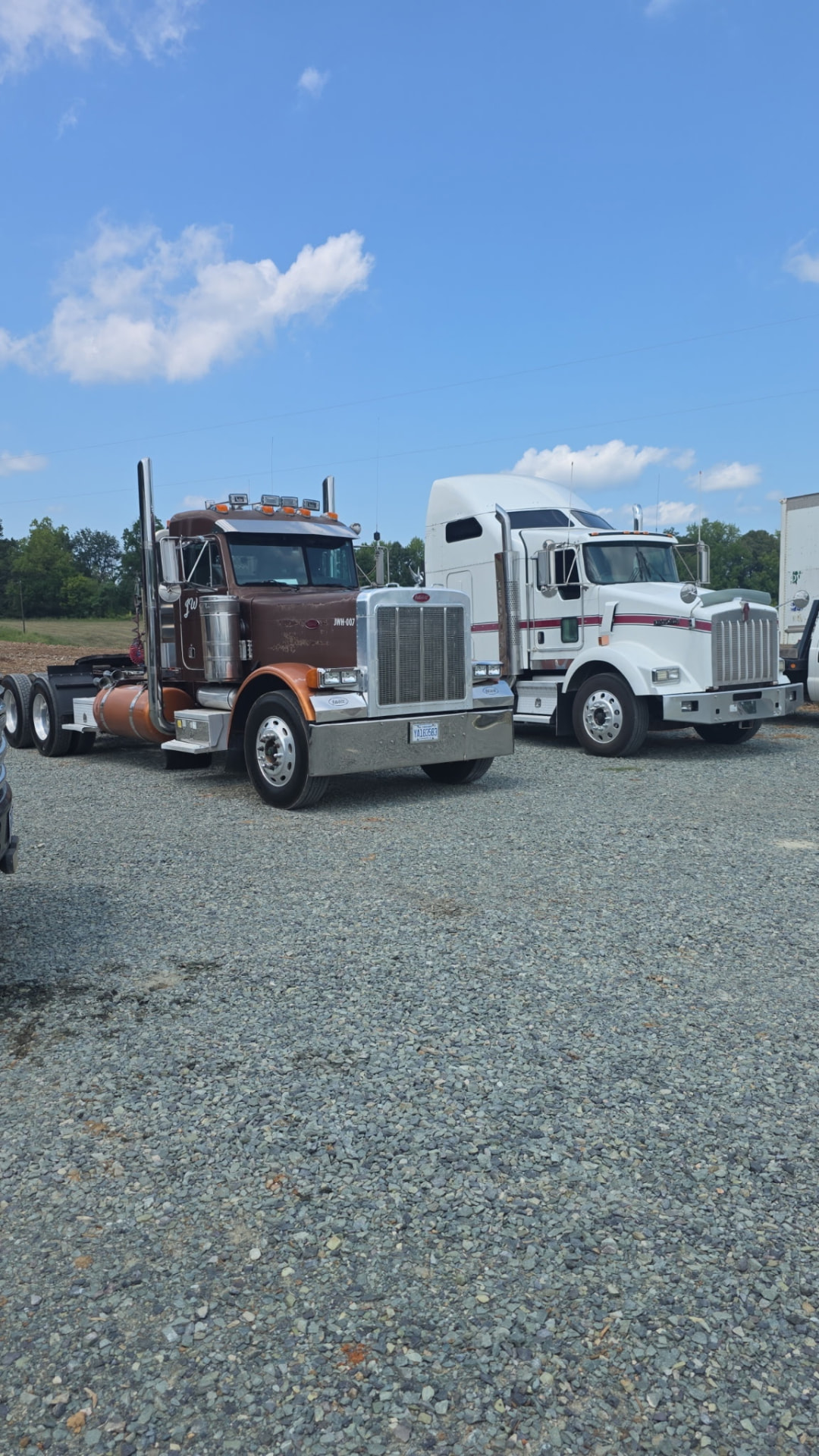 JW Hart Transport brown Peterbilt parked next to a white Kenworth in a gravel yard