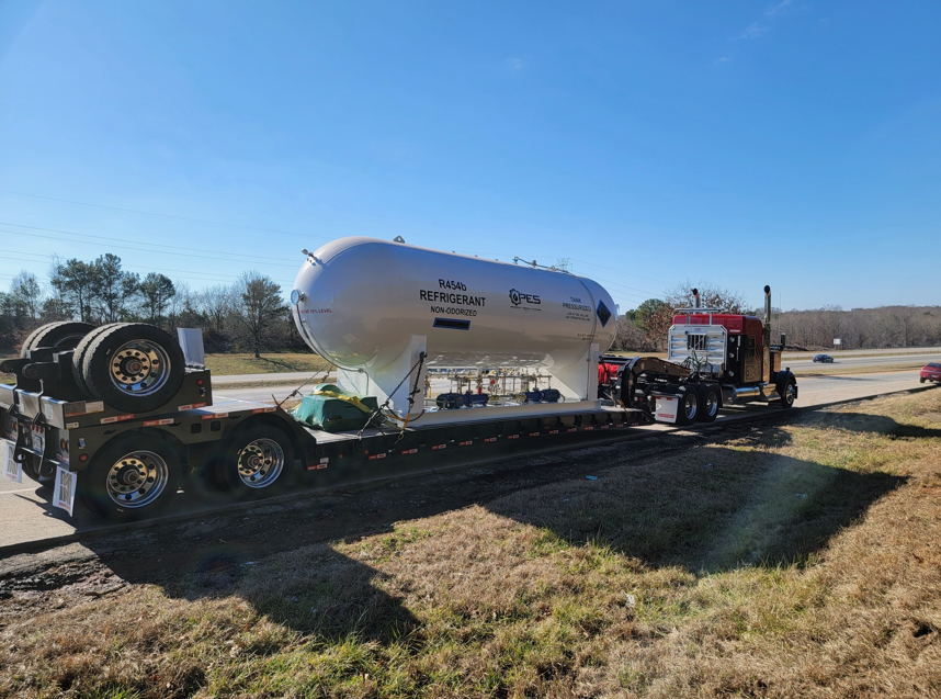 JW Hart Transport semi hauling a large refrigerated tank on a specialized flatbed trailer