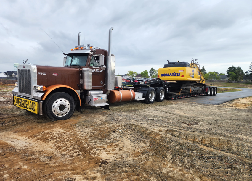 JW Hart Transport oversize load truck hauling a Komatsu excavator